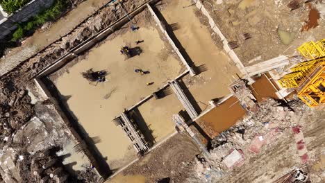 aerial view of a construction site with workers and excavated foundations