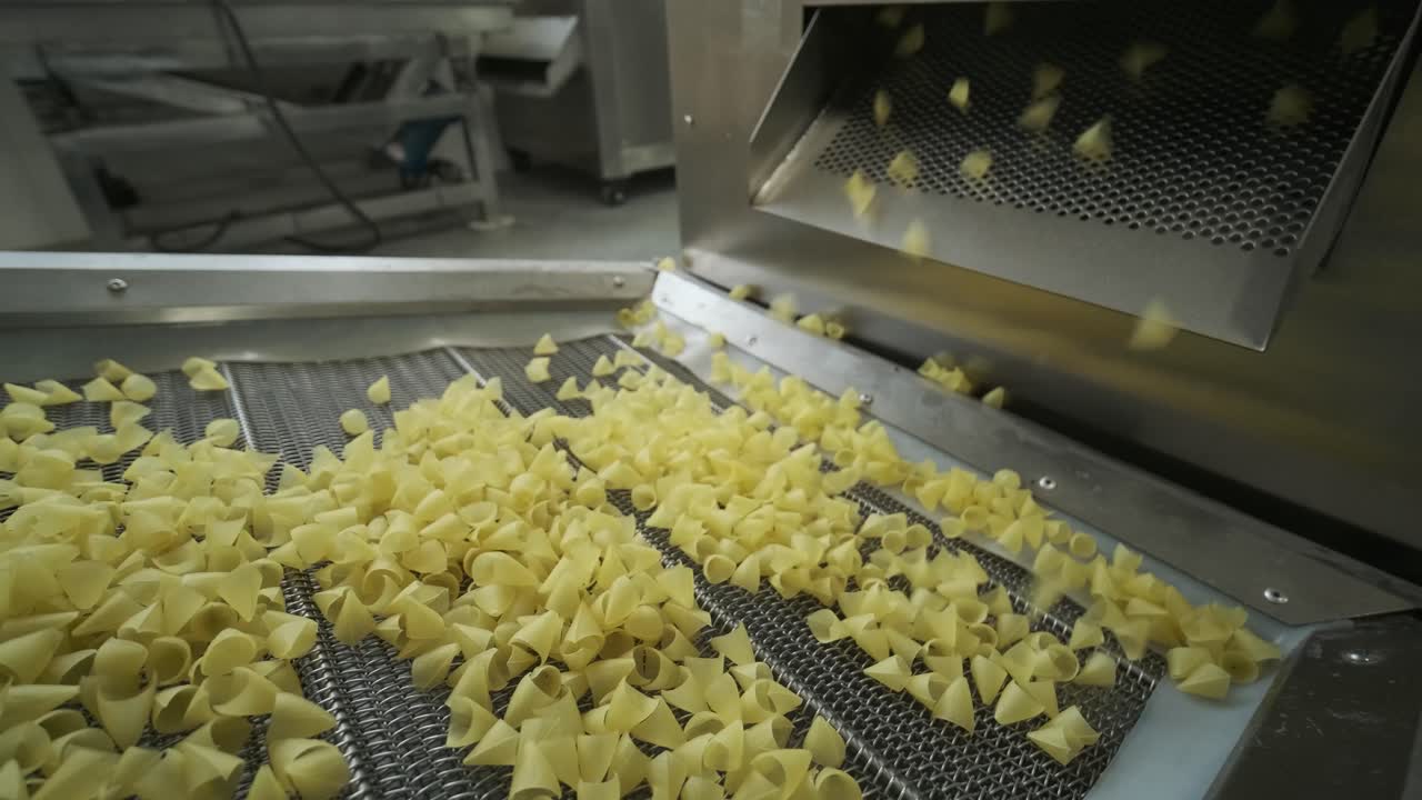Production factory line moves potato snackes. Production line of the pasta factory, pasta production