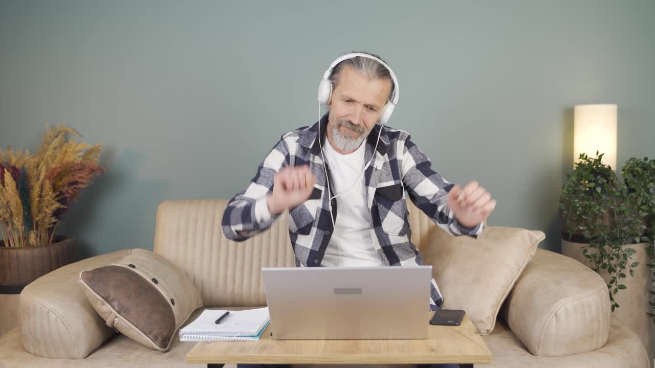 Man looking at laptop is happy and dancing.