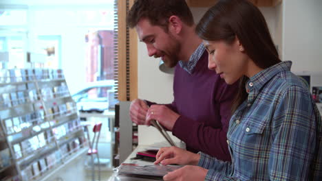 Hombre-Y-Mujer-Trabajando-Detrás-Del-Mostrador-En-Una-Tienda-De-Discos