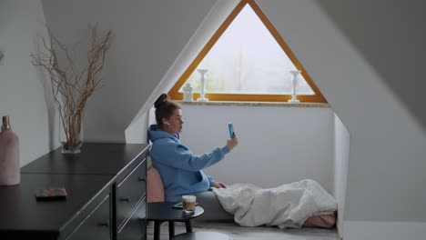 woman taking a selfie video call in a cozy room