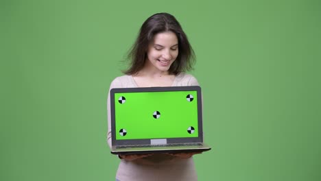 young happy beautiful woman showing laptop and looking down