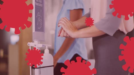 animation of virus icons over caucasian woman disinfecting hands