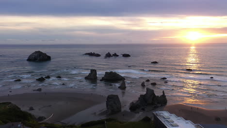 Puesta-De-Sol-Vibrante-Reflejada-En-El-Océano-Sereno-Con-Pilas-De-Mar-En-Bandon,-Oregon