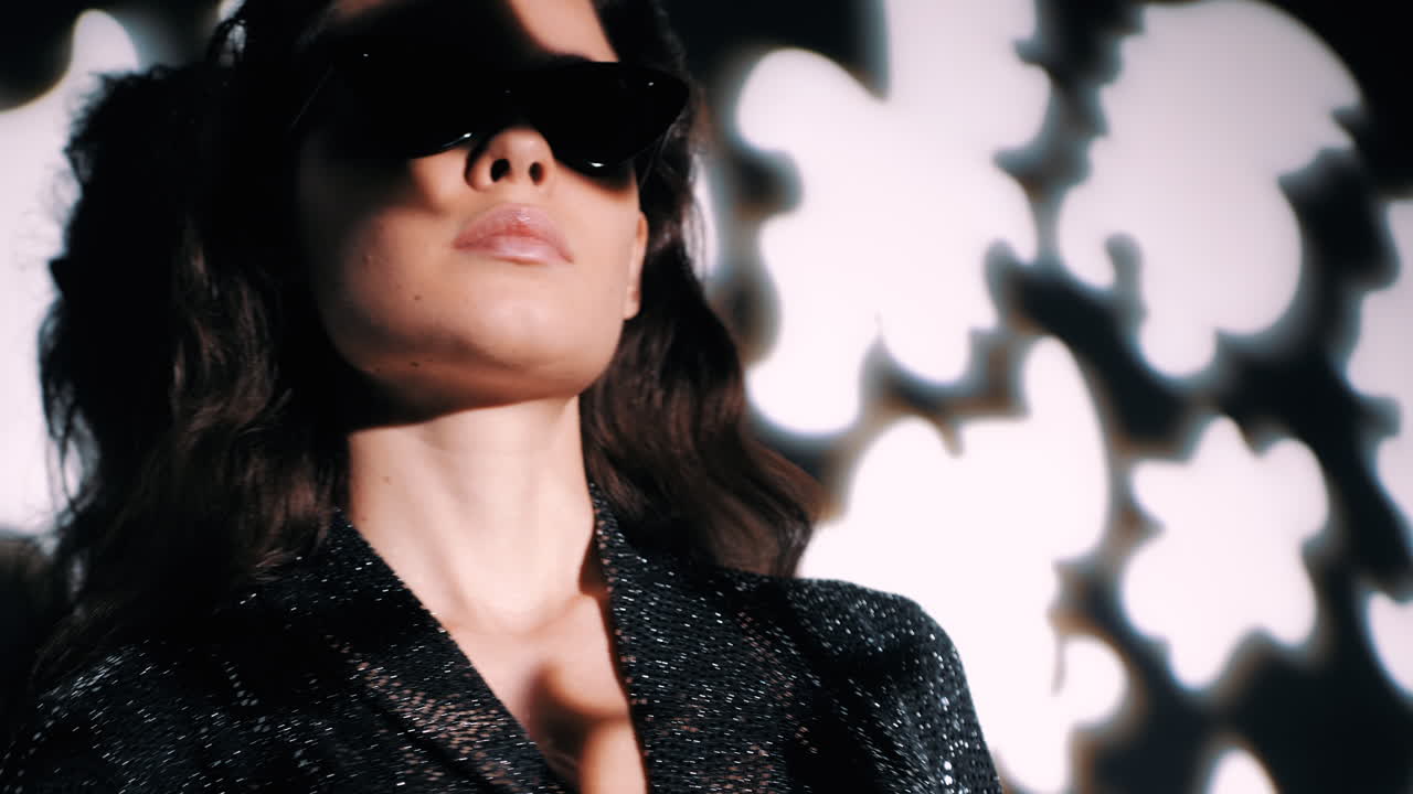 검은 옷을 입은 선글라스를 입은 세련된 여성