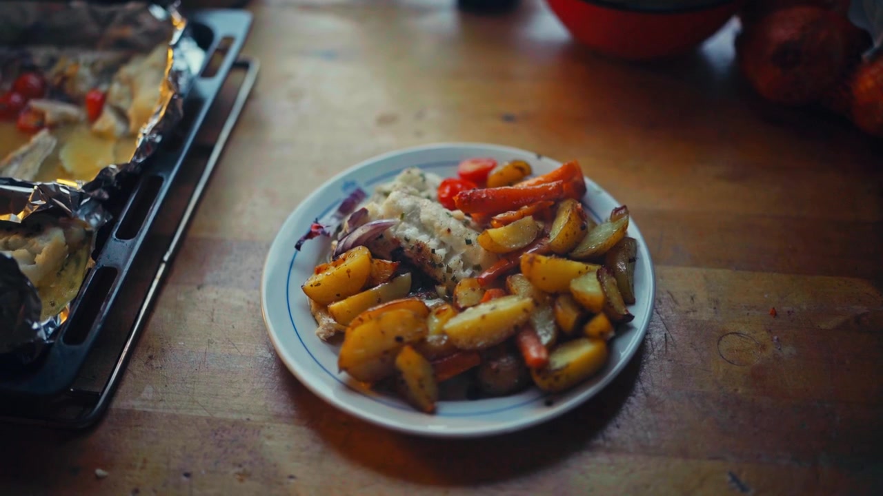 Patate arrosto, carote e altre verdure su un piatto. Inquadratura dall'alto.