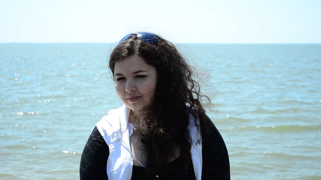 La ragazza di fronte al mare. Sorriso sul viso della ragazza.
