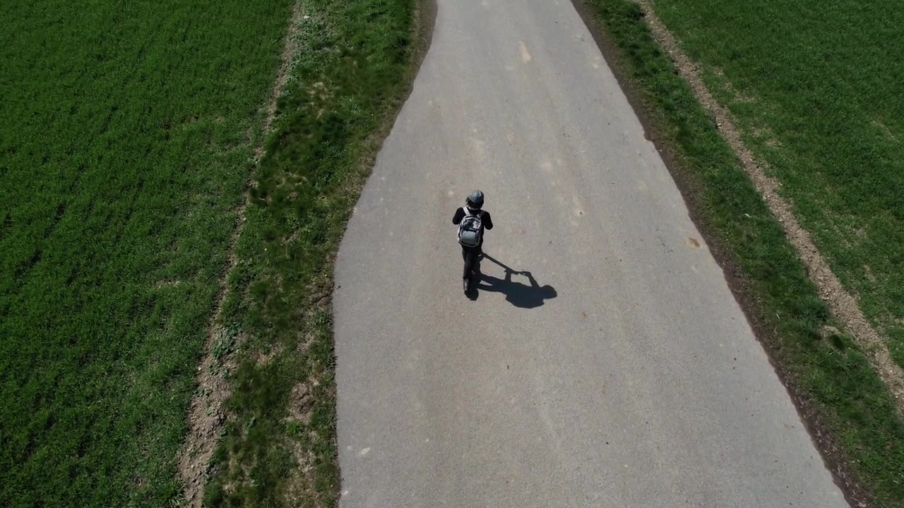 Riding a scooter outside the city between the fields