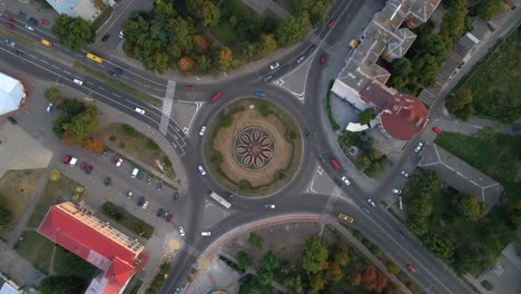 4k aerial view of roundabout road with circular cars in small european city at summer day