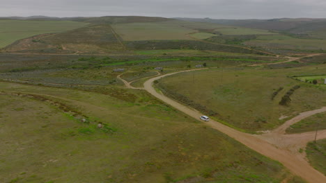 Cinematic-shot-of-vehicle-driving-in-African-landscape.-Dirt-roads-leading-around-family-farms-in-countryside.-South-Africa