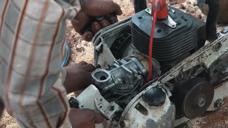 medium shot of a man working on a chainsaw engine