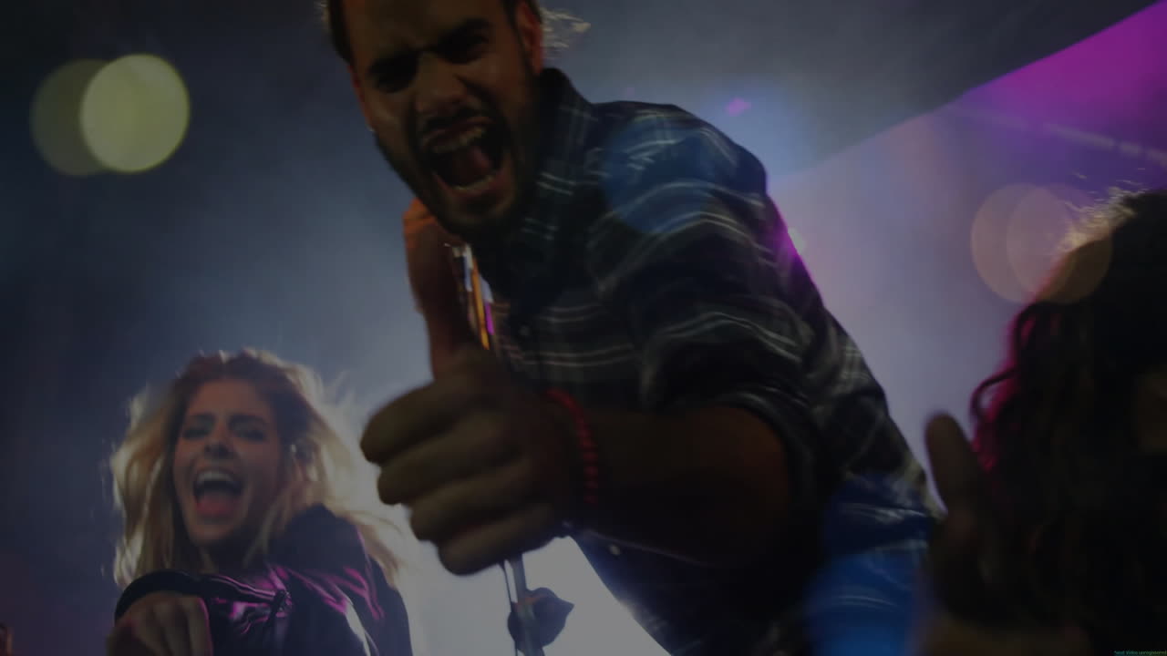 Singing into microphone, man and woman performing over colorful light animation