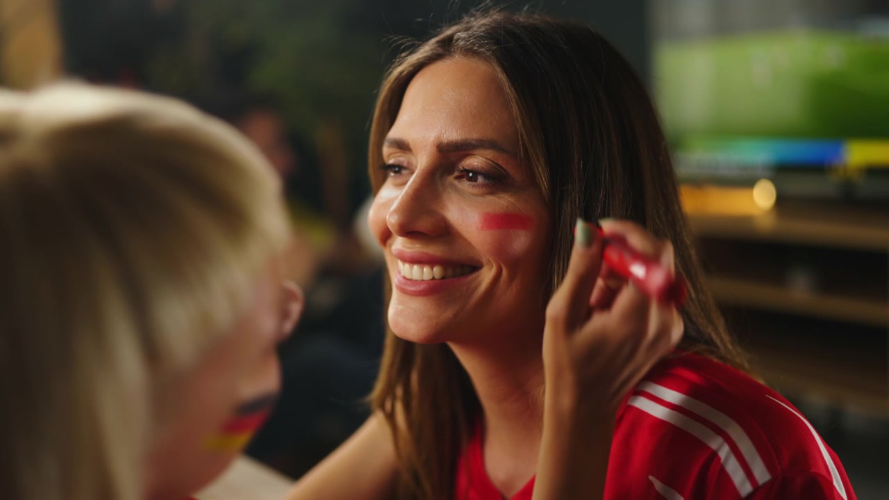 Woman Applying Face Paint for Soccer Match