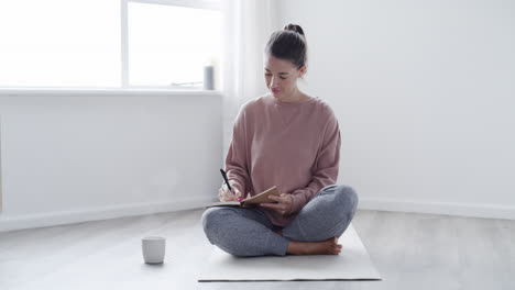 mujer joven escribiendo notas sinceras en un diario