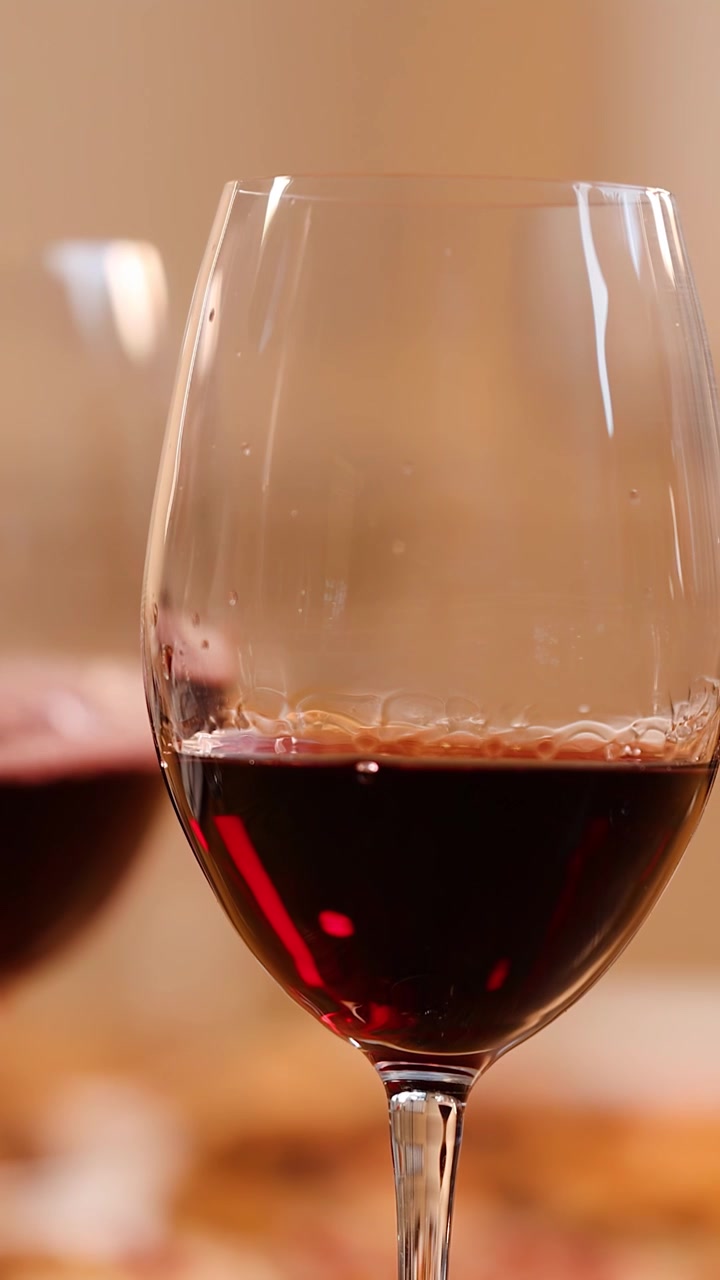 Close-up de vinho tinto sendo derramado em uma taça durante uma celebração de jantar aconchegante em restaurante