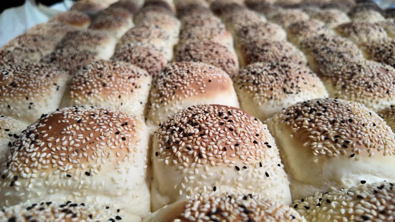 Freshly Baked Bread Rolls with Sesame Seeds Arranged in Rows
