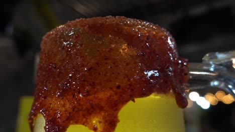 close-up shot of a glass rim covered with sauces in a bar at night