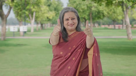 Happy-Indian-old-woman-showing-thumbs-up-in-park