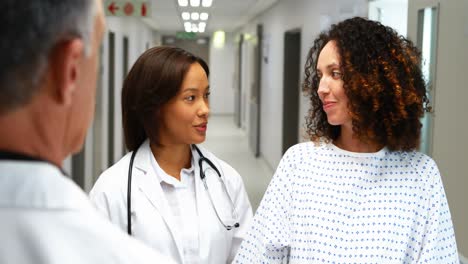 pregnant woman interacting with doctors in corridor