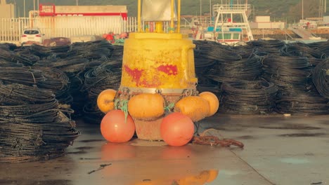 The-asphalt-mirroring-the-water-embodies-the-essence-of-a-coastal-Spanish-fishing-village,-with-a-yellow-buoy-adding-to-its-distinctive-charm