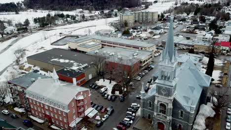 drone shot flying close around a beautiful church in winter in the small village of st-raymond in quebec, canada