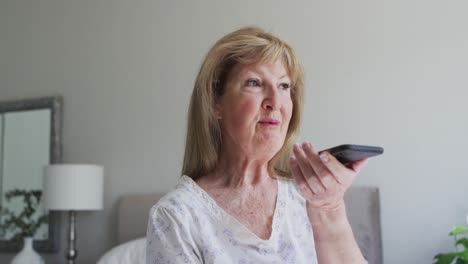 Mujer-Mayor-Hablando-Por-Teléfono-Inteligente-En-Casa