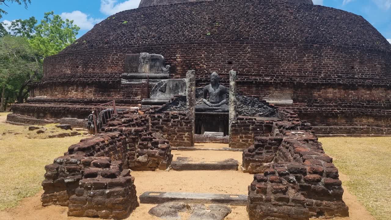 Revealing shot of the ruins of Pabalu Vehera, an ancient stupa in historic Polonnaruwa, Sri Lanka, bathed in bright sunlight, highlighting the rich heritage of the Sinhala kingdom