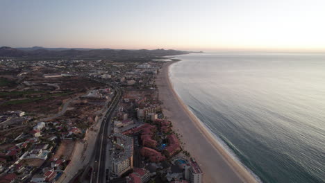 Carretera-Costera-En-Los-Cabos,-México-Rodeada-De-Resorts-Y-Hoteles-En-Una-Tranquila-Puesta-De-Sol-En-El-Océano