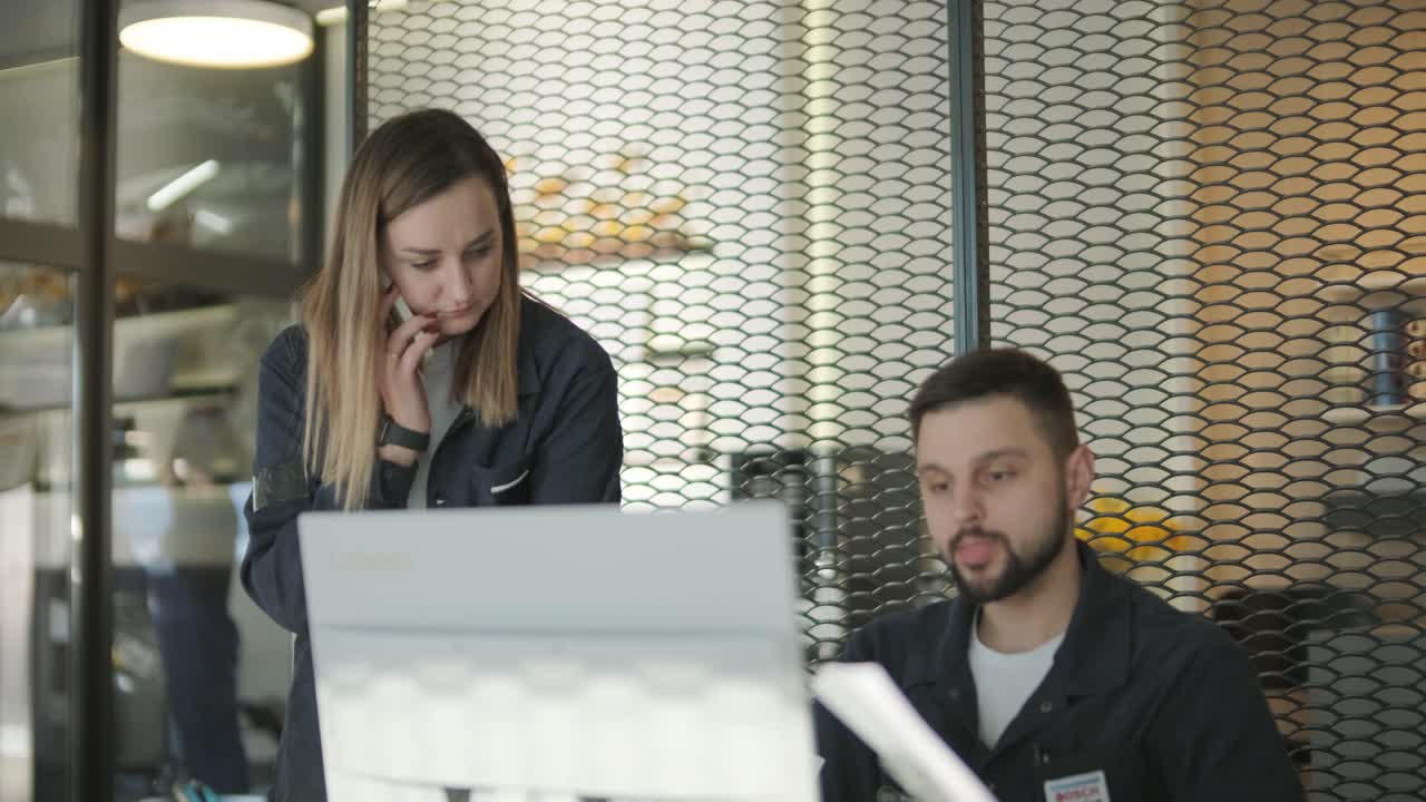 gerente femenina discutiendo la reparación de vehículos con el mecánico en el taller de reparación de automóviles