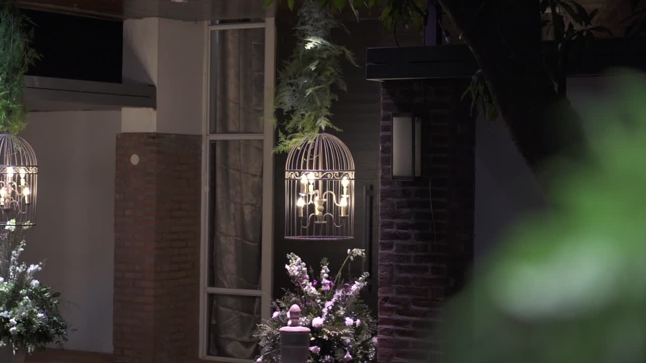 Hanging elegant night event lighting with vintage lanterns and floral decoration