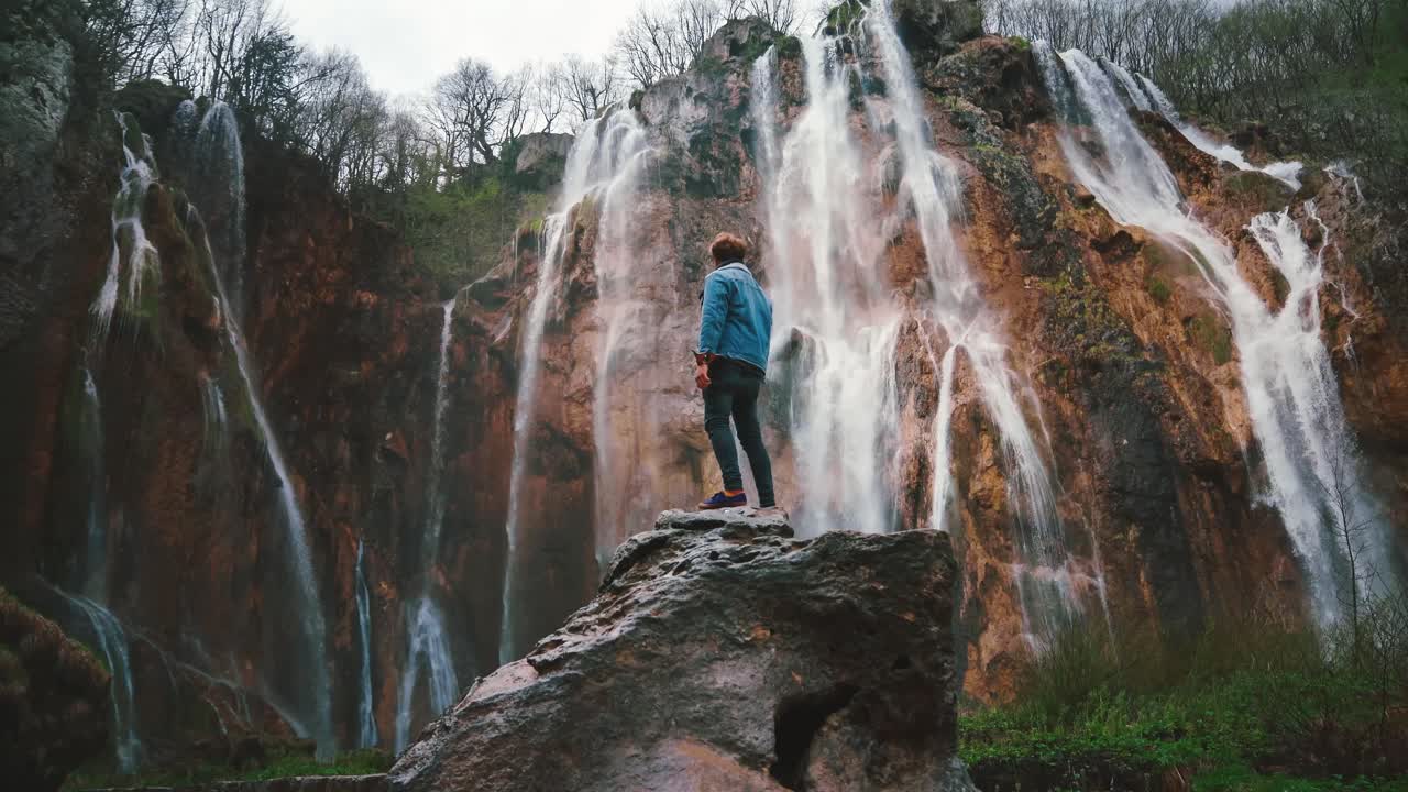 hermosa cinemagrafía 4k uhd de cascadas en el parque nacional de plitvice en croacia a principios de verano con un joven