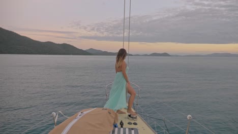 sexy young woman standing at the deck of boat sailing in the ocean - hook passage at whitsunday in qld, australia