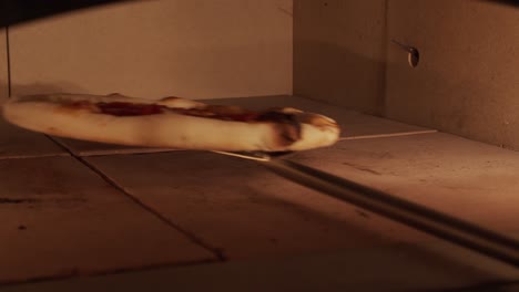 primer plano de la pizza horneada dentro del horno de pizza