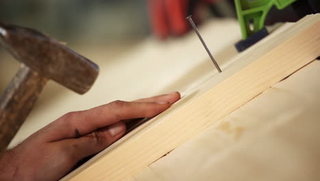 Carpenter driving a nail into wood