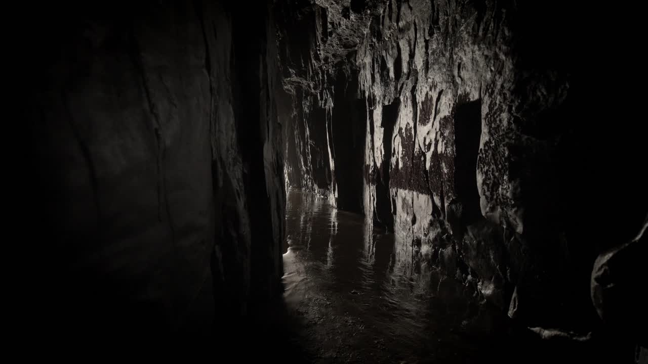 cueva oscura junto al océano con luz que atraviesa el final del túnel
