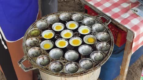 cooking thai eggs in a traditional pan