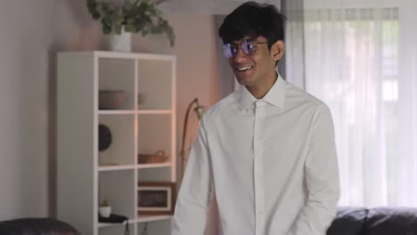 young and happy asian man smiling while getting dressed formally