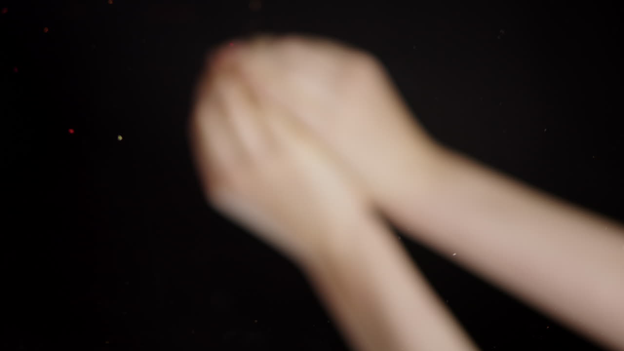 Close-up of Hands Clapping, Releasing Red and Green Spices