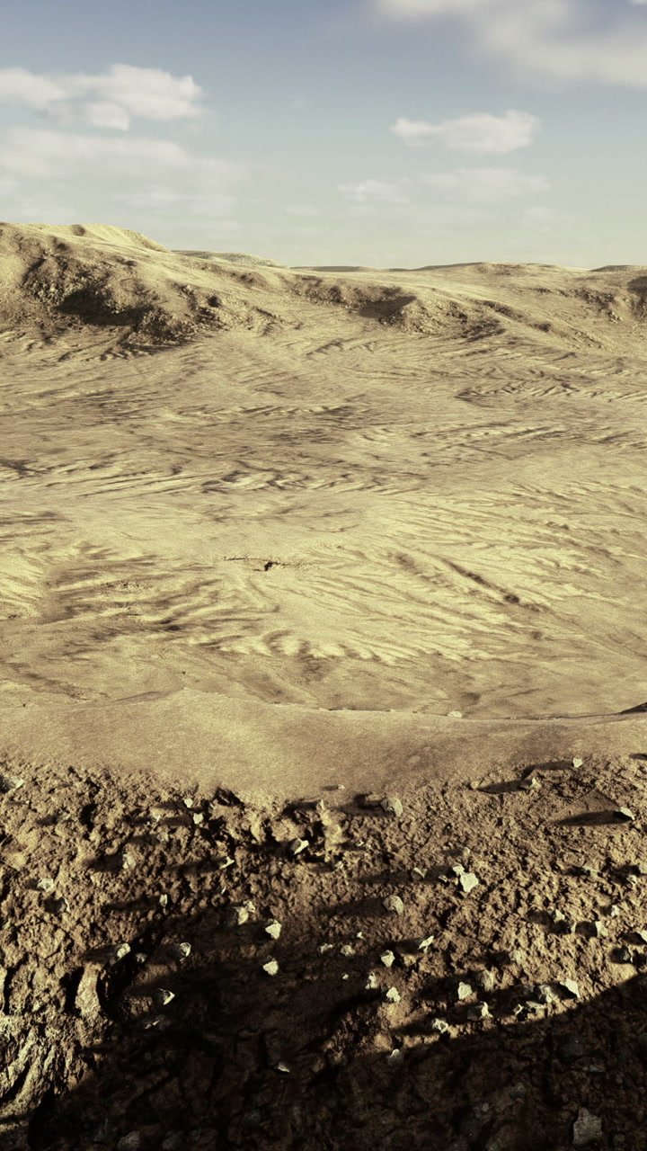 Expansive view of dry terrain with scattered rocks and hills under blue sky