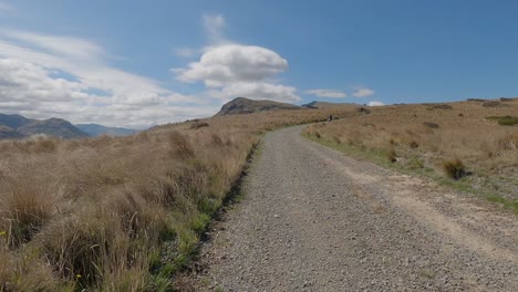 pov off-road cycling towards interesting cloud formations as motorbike passes - bossu road, canterbury