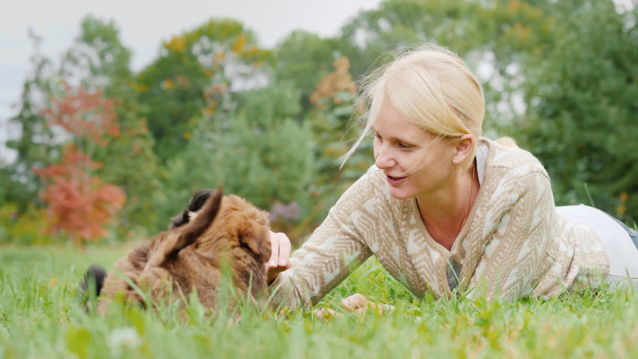 잔디밭에서 강아지와 노는 여자