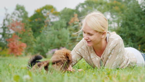Woman-Playing-With-Puppies-on-a-Lawn