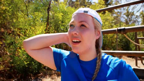 mujer pensativa con gorra en el campamento de entrenamiento