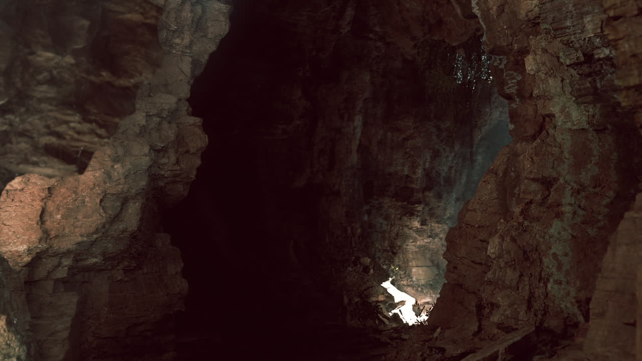 una entrada oscura de la cueva con la luz brillando a través