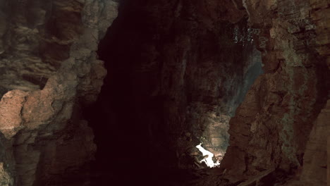 a dark cave entrance with light shining through