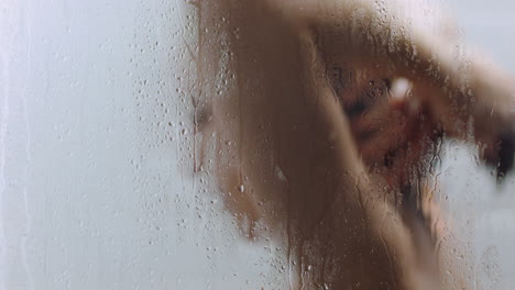 mujer atractiva tomando una ducha tocando la piel húmeda disfrutando de un spa de lujo limpiando el cutis suave