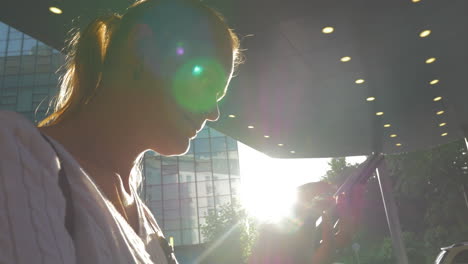 Mujer-Con-Celular-En-La-Ciudad-Contra-El-Sol-Brillante