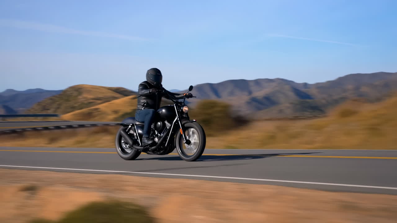 Motociclista che viaggia su una strada panoramica di montagna
