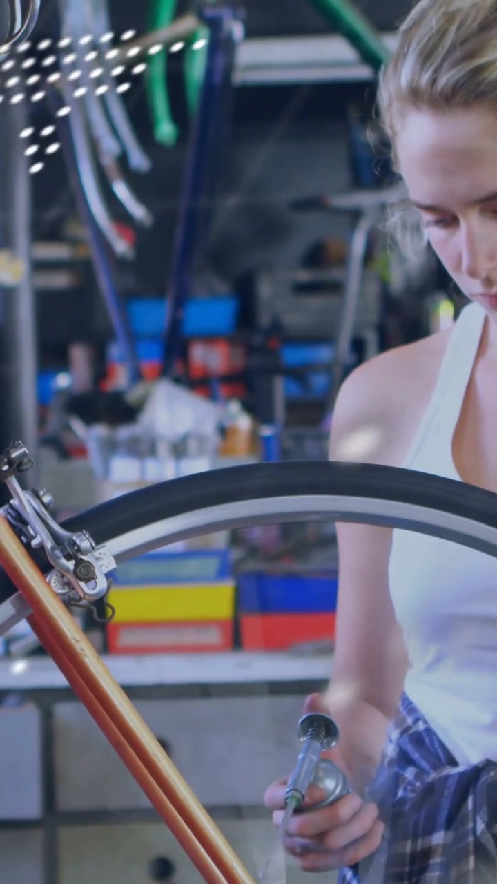 Vertical video: Woman reaching hub, tightening hub, repairing wheel, overlay sweeping over torso