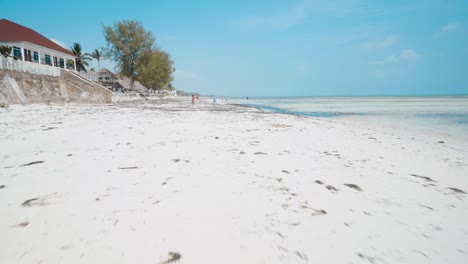 4K-Aerial-flying-drone-shot-of-Kiwengwa-beach-washed-with-turquoise-Indian-ocean-waves